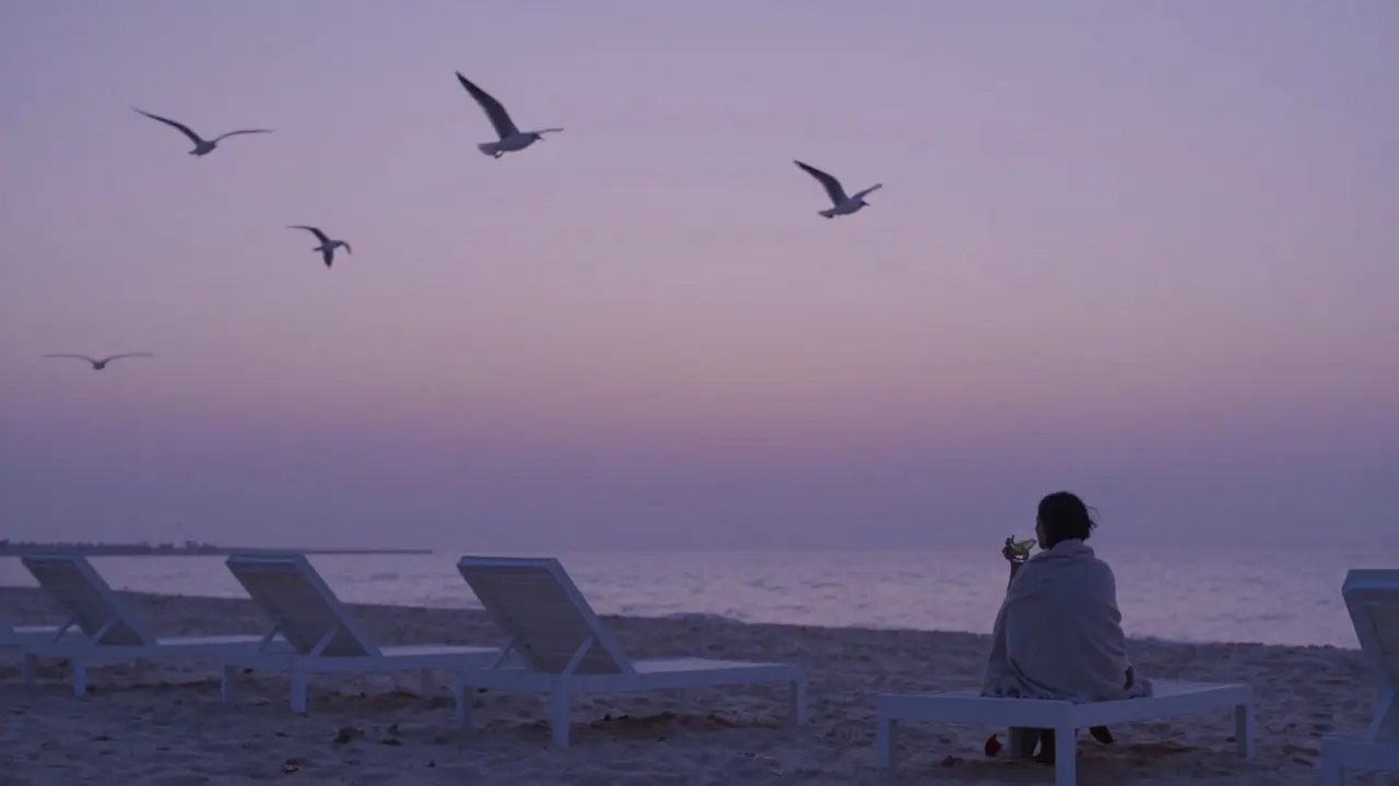 A solitary figure at Atmosphere Beach Dubai watching the unlit horizon at dusk.